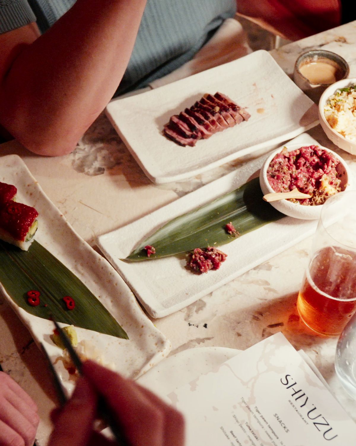 Tataki and tartare served on marble, a ShiYuzu menu beside it